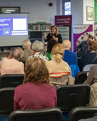 Libraries NI Making A Difference - photo of speaker and attendees at a Changing Attitudes to Ageing event in Derry Central Library