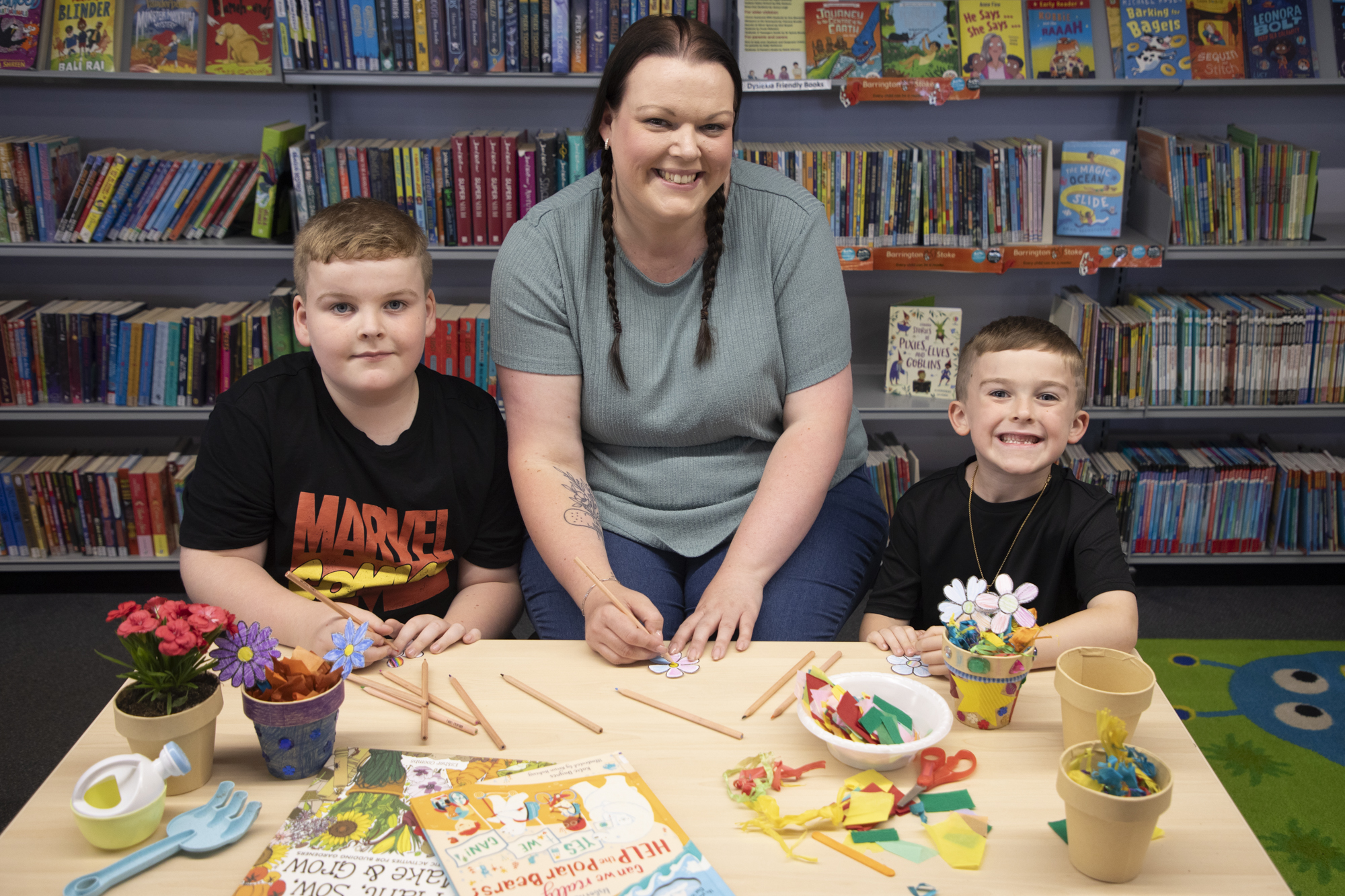 Photo of Riley and Hunter, pictured with their mum Laura, help launch Go Green with Libraries NI by getting creative with a fun junk art craft using recycled materials in Glengormley Library.