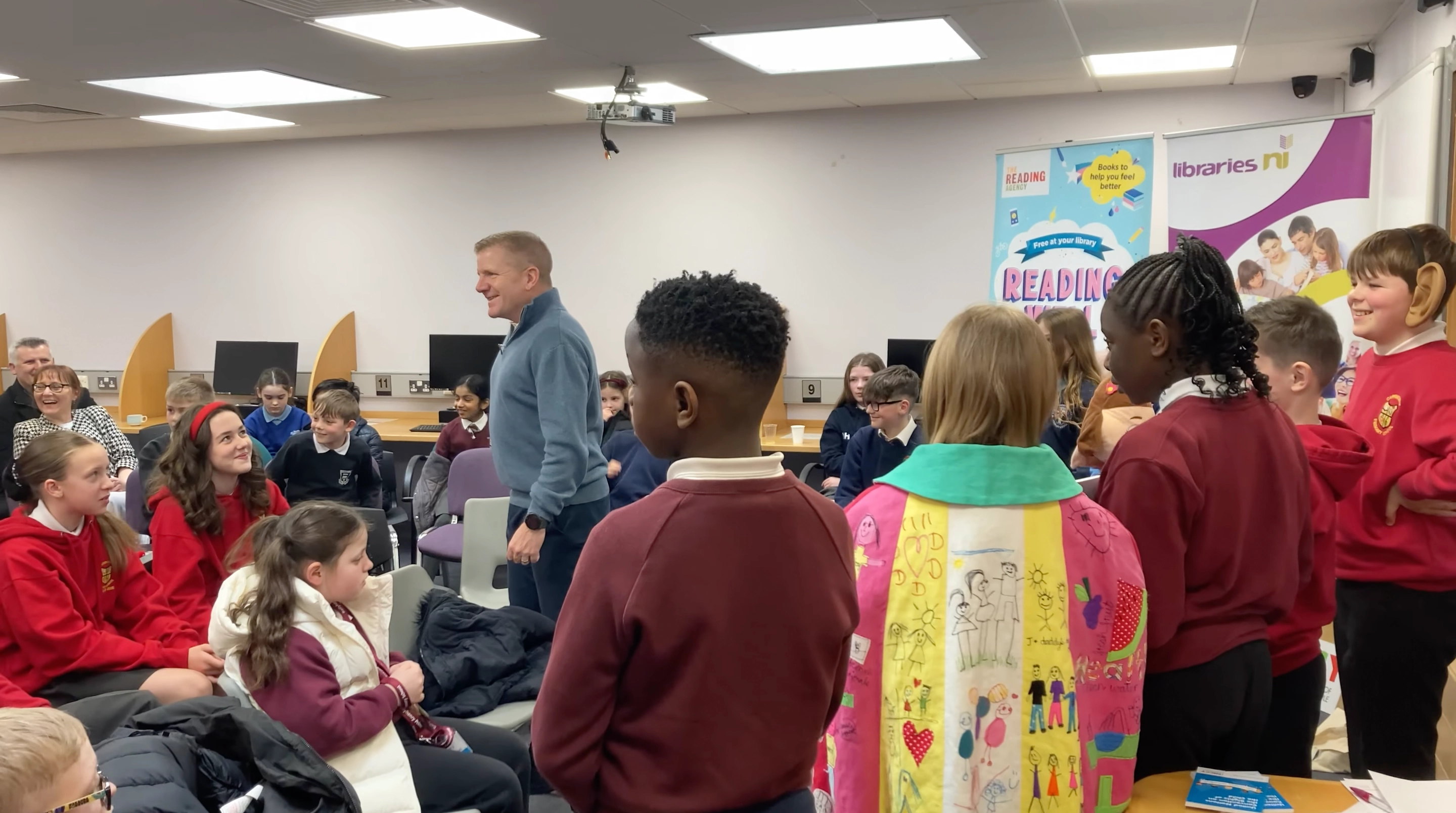 The Northern Ireland Commissioner for Children and Young People Chris Quinn and children in the library